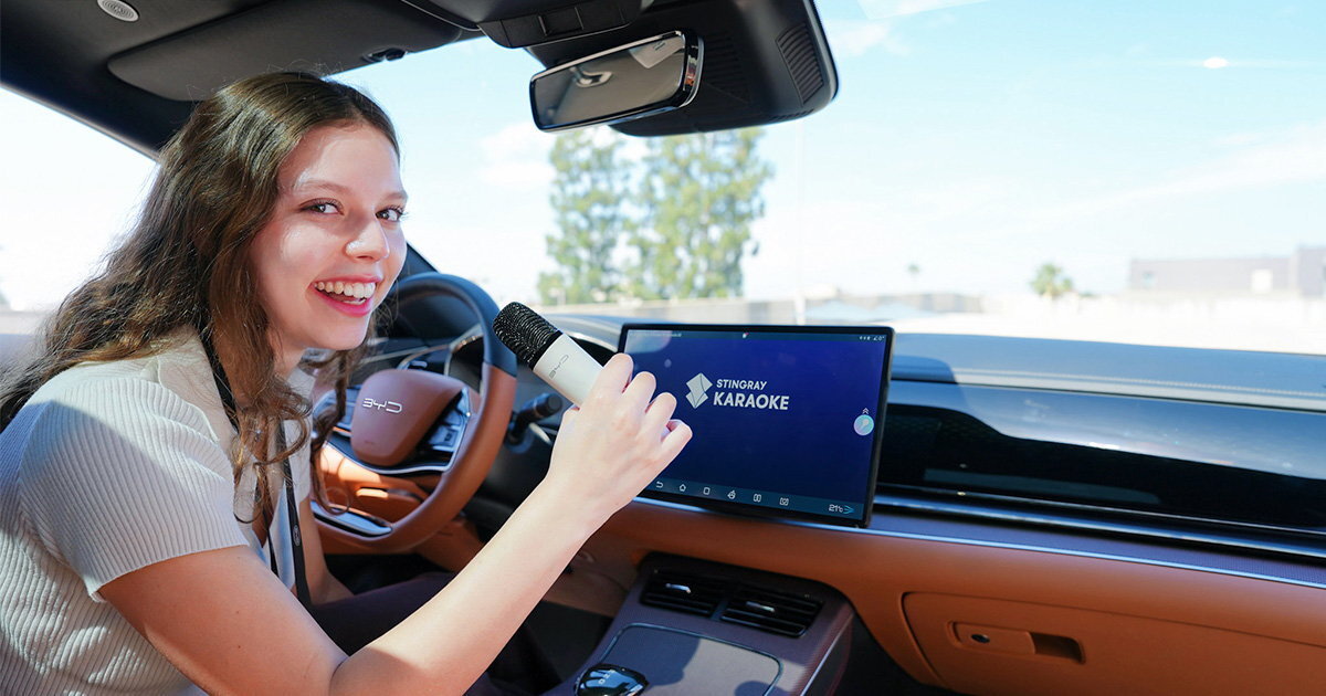 A young woman trying the Stingray karaoke system in a byd car. karaoke wheel: soon choir highway